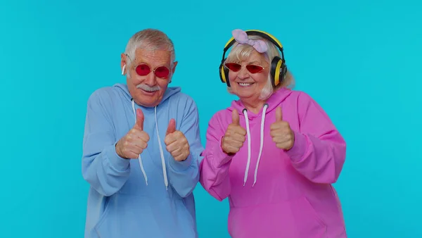 Mature stylish grandparents pensioners listening music via headphones, dancing disco fooling around — Stock Photo, Image