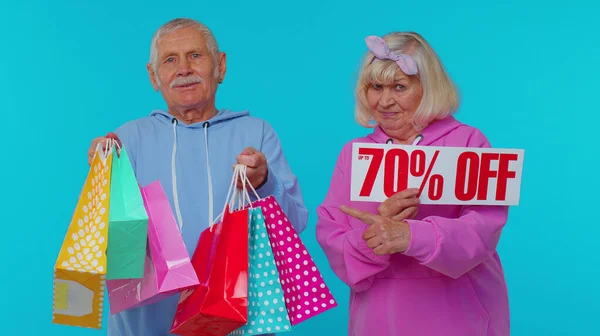 Senioren-Großeltern zeigen Einkaufstüten und bis zu 70 Prozent Rabatt am Black Friday — Stockfoto