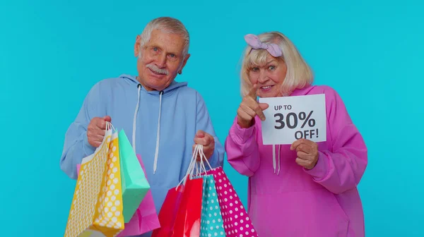 Senior-Großeltern zeigen Einkaufstüten und bis zu 30 Prozent Rabatt auf Werbebanner, Black Friday, Feiertag — Stockfoto