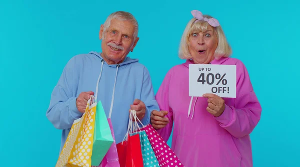Senioren-Großeltern zeigen Einkaufstüten und bis zu 40 Prozent Rabatt am Black Friday — Stockfoto