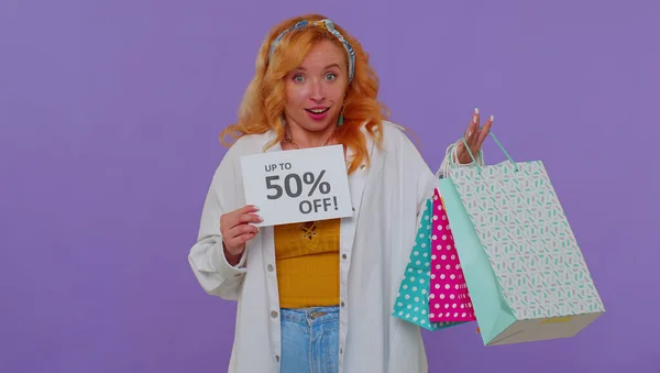Menina ruiva alegre mostrando sacos de compras, Até 50% Off banner inscrições, Black Friday — Fotografia de Stock