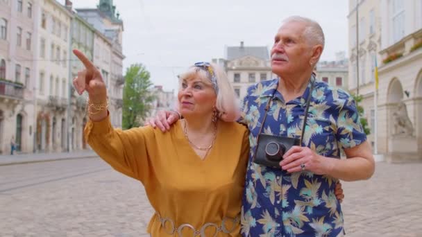 Anciano viejo elegante familia pareja turistas hombre, mujer de vacaciones viajando por la calle de la ciudad — Vídeo de stock