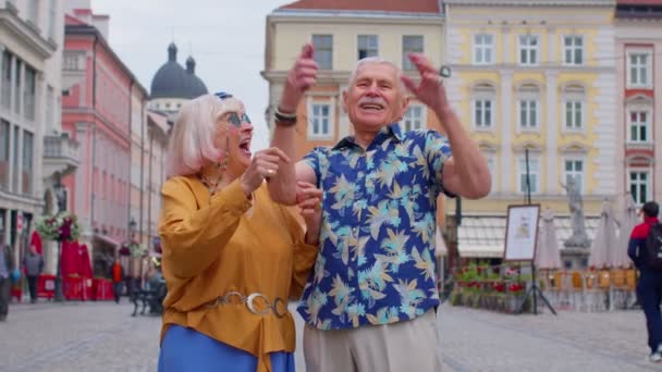 Idős turisták használják mobiltelefon gépelés böngészés mondani wow igen, kiderült, nagy győzelem hír — Stock videók