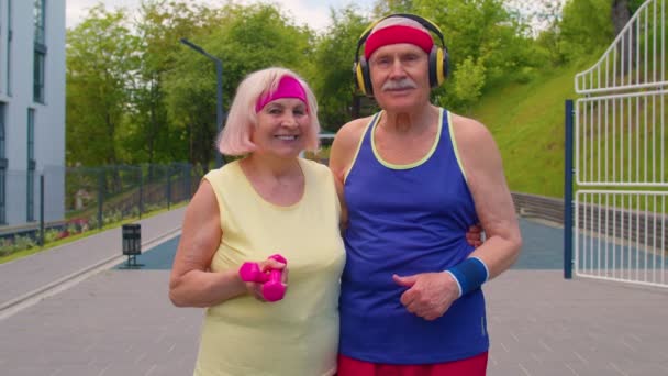 Homme âgé actif, femme après le sport haltères haltères exercices, souriant en regardant la caméra — Video