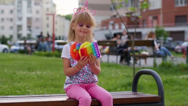 Dítě dívka dítě ukazuje mnoho barevné squishy silikonové bubliny smyslové hračky, dítě hraje pop it game — Stock video