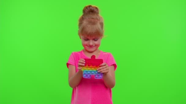 小女孩玩毛茸茸的硅胶泡泡毛绒玩具简单的酒窝弹出游戏，绿色彩色键 — 图库视频影像