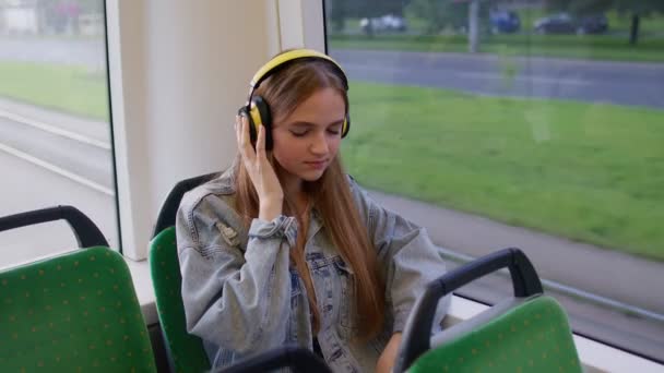 Mladá žena nosí sluchátka poslech hudby, zábavný relax tanec při cestování autobusem do města — Stock video