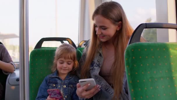 Matka s dcerou cestují autobusem domů, hrají na smartphonu, procházejí sociální média — Stock video