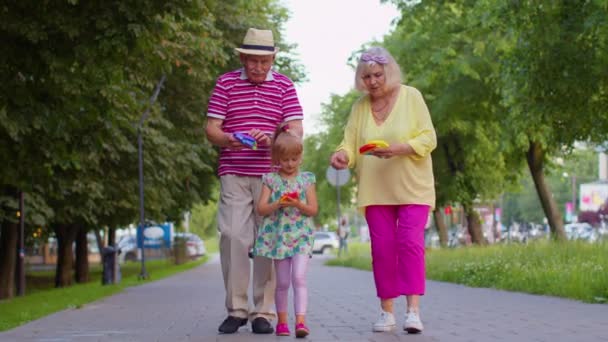 Lächelnde Großmutter Großvater mit Enkelin beim Quetschen Anti-Stress-Spiel — Stockvideo
