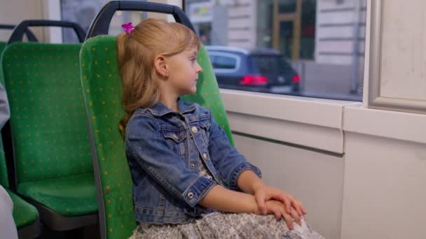 현대의 대중 버스나 전차를 타고 있는 소녀 승객의 모습, 창밖을 내다보는 모습 — 비디오