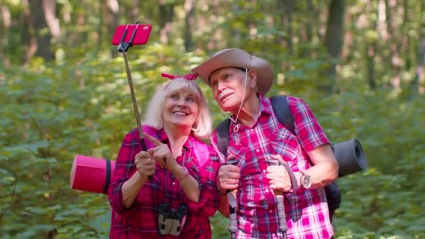 Старший бабуся дід блогер туристів, які фотографують селфі на мобільному телефоні в дереві — стокове відео