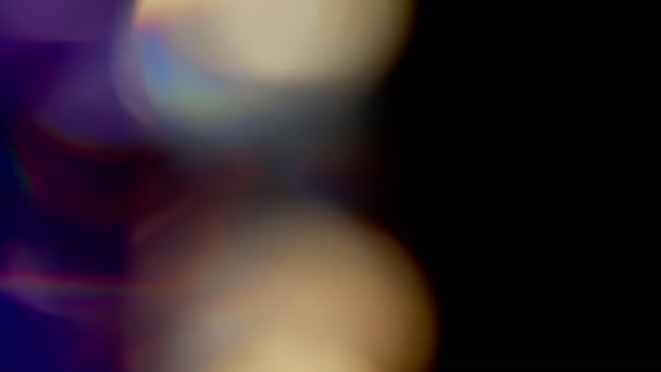 Des fuites de lumière multicolore filment sur fond noir, des éclats de fuite de lentilles recouvrent les transitions — Video