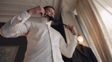 Damat papyonu ayarlar, geline gitmeye hazırlanır, beyaz gömlekli iş adamı, düğün günü