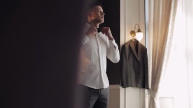 Damat papyonu ayarlar, geline gitmeye hazırlanır, beyaz gömlekli iş adamı, düğün günü