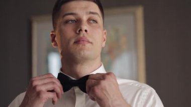 Damat papyonu ayarlar, geline gitmeye hazırlanır, beyaz gömlekli iş adamı, düğün günü