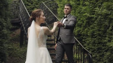 Yeni evliler, gelinle beyaz damat parkta merdivenlerde kalın, düğün çifti, aşık erkek ve kadın