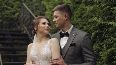 Yeni evliler, gelinle beyaz damat parkta merdivenlerde kalın, düğün çifti, aşık erkek ve kadın