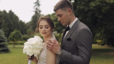 Yeni evliler, beyaz damat, yürüyen, kucaklaşan, parkta sarılan, düğün çifti.