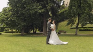 Yeni evliler, beyaz damat, yürüyen, kucaklaşan, parkta sarılan, düğün çifti.