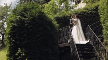 Yeni evliler, gelinle beyaz damat parkta merdivenlerde kalın, düğün çifti, aşık erkek ve kadın