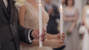 Yeni evliler, gelin ve damat kalkın ve kilisede dua edin, ellerinde mumlar, düğün töreni