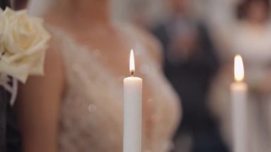 Yeni evliler, gelin ve damat kalkın ve kilisede dua edin, ellerinde mumlar, düğün töreni