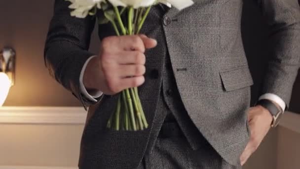 Bräutigam mit Brautstrauß in den Händen zu Hause bereitet sich darauf vor, zur Braut zu gehen, Nahaufnahme, Zeitlupe — Stockvideo