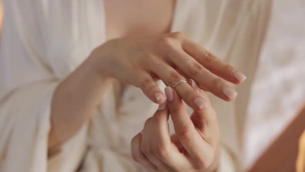 Νύφη με νυχτικό, πέπλο με δαχτυλίδι αρραβώνων κοντά στο παράθυρο. Το πρόσωπο από κοντά χαμογελάει. Πρωί γάμου — Αρχείο Βίντεο