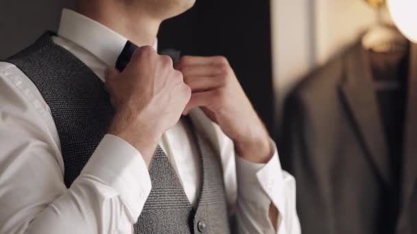 El novio ajusta la pajarita, preparándose para ir a la novia, hombre de negocios con camisa blanca, día de la boda — Vídeo de stock