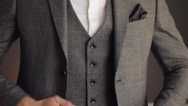 Buttoning jacket with hands close up, man in suit fastens buttons on his jacket preparing to go out — Stock Video