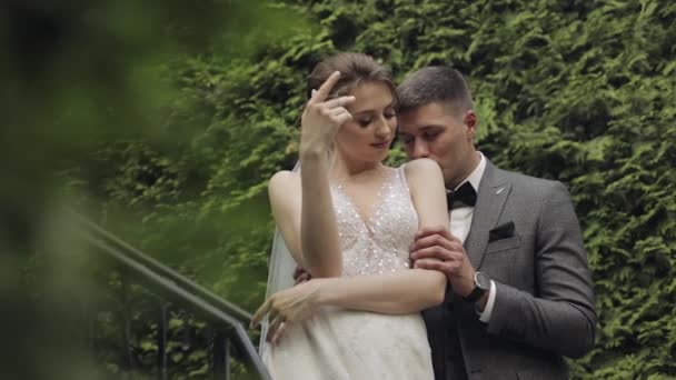 Pasgetrouwden, blanke bruidegom met bruid blijven op de trap in park, huwelijk koppel, man en vrouw verliefd — Stockvideo