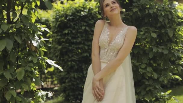 Bella e bella sposa in abito da sposa e velo nel parco in attesa di sposo. Rallentatore — Video Stock