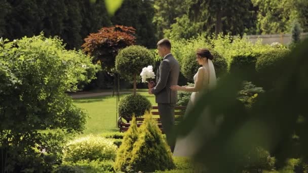 Bella sposi caucasici sposa e lo sposo con bouquet nel parco, coppia di sposi primo incontro — Video Stock