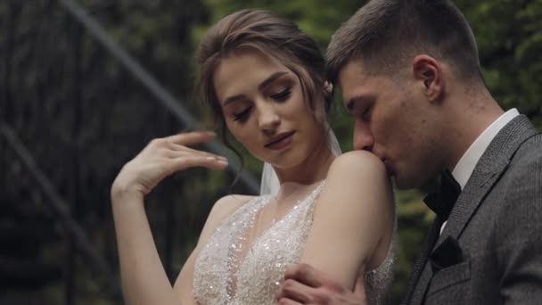 Pengantin baru, pengantin pria kaukasia dengan pengantin wanita tinggal di tangga di taman, pasangan suami-istri, pria dan wanita jatuh cinta — Stok Video