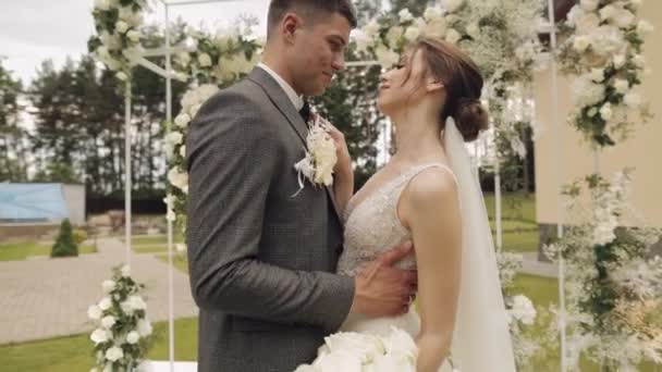 Frischvermählte, kaukasischer Bräutigam mit Braut beim Gehen, Umarmungen, Umarmungen im Park, Hochzeitspaar — Stockvideo