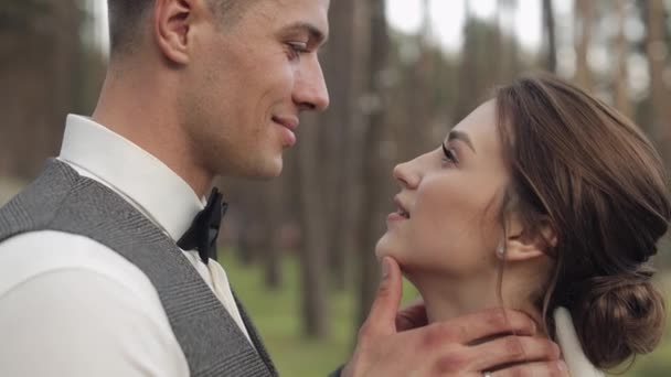 Jeunes mariés, marié caucasien avec mariée marchant, embrassant, câlins dans le parc, couple de mariage — Video