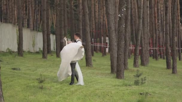 Härliga nygifta kaukasiska brud brudgummen dansar i parken, gör kyss, bröllop par familj — Stockvideo