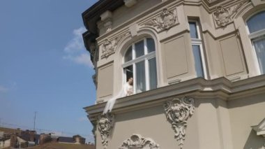 Pencere pervazında oturan gelinlik, düğün sabahı hazırlıkları gecelikli kadın, duvak.