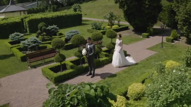 Preciosos recién casados caucásicos novia y novio con ramo en el parque, pareja de boda primera reunión — Vídeo de stock