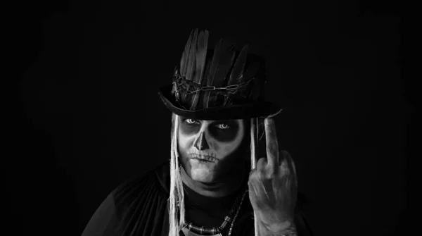 Finsterer Mann mit Totenkopf-Make-up, das Gesichter macht und Mittelfinger zeigt. Schlechte Geste. Halloween — Stockfoto