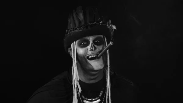 Frightening man in skeleton Halloween cosplay costume smoking cigar, smiling, laughing — Stock Photo, Image
