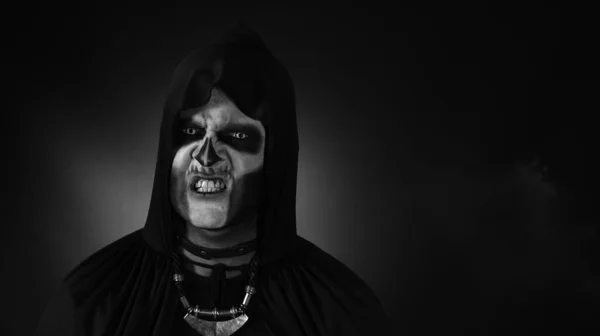 Finsterer Mann mit Halloween-Skelett-Make-up macht Gesichter, blickt in die Kamera und versucht Angst zu verbreiten — Stockfoto