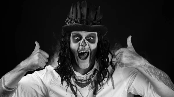 Τρομακτικός χαμογελαστός άντρας με στολή αποκριάτικου σκελετού που δείχνει τους αντίχειρες. Μαύρο φόντο — Φωτογραφία Αρχείου