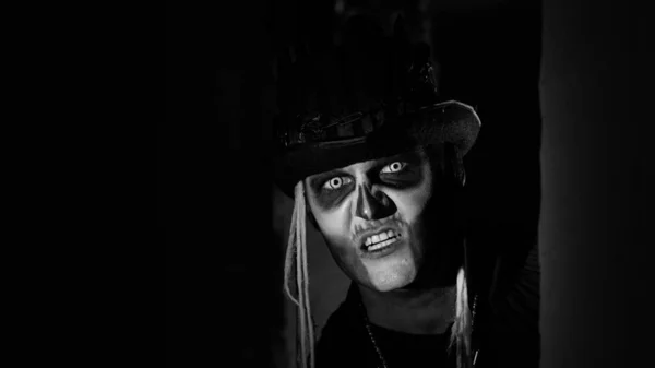 Τρομακτικό άνθρωπος με αποκριάτικο σκελετό μακιγιάζ εμφανίζεται από τη σκοτεινή γωνία, προσπαθεί να τρομάξει — Φωτογραφία Αρχείου