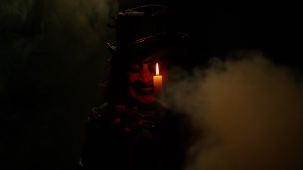 Синістерка з лякаючим макіяжем відьом Хеллоуїна в костюмі роблячи магічні ритуали вуду зі свічкою — стокове відео