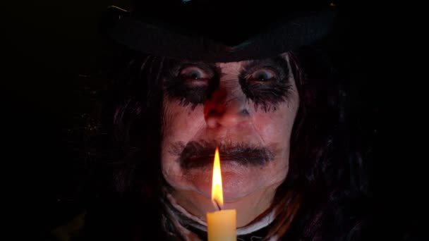 Finstere Frau mit gruseliger Halloween-Hexe im Kostüm, die Voodoo-magische Rituale mit Kerze macht