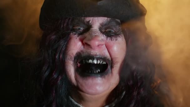 Зловісна старша жінка в карнавальних костюмах відьми Хелловін, намагаючись налякати — стокове відео