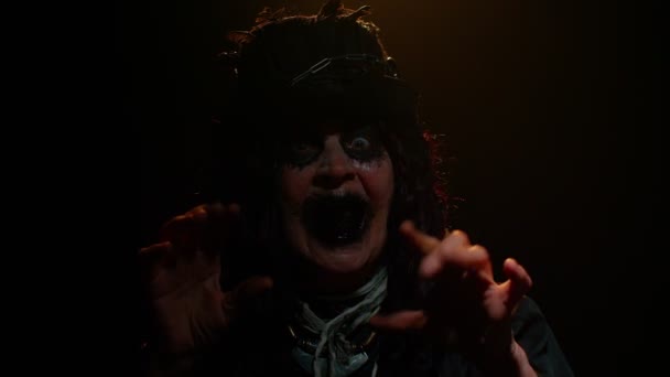 Przerażająca starsza kobieta z makijażem czarownicy Halloween próbuje przestraszyć, pokazując czarny brudny język — Wideo stockowe