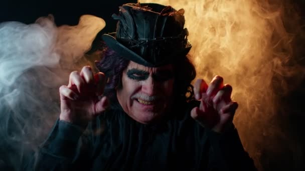 Hombre siniestro con horrible horrible maquillaje brujo de Halloween en traje haciendo caras tratando de asustar — Vídeos de Stock