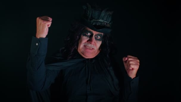 Griezelige volwassen man grootvader met Halloween stijlvolle heksenmake-up vieren win vreugde zeggen Ja — Stockvideo